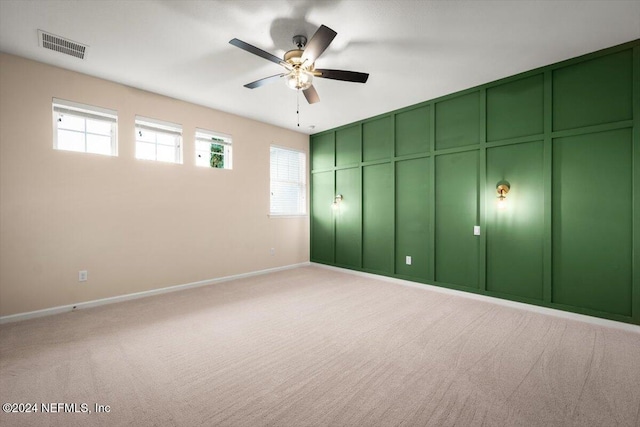 unfurnished bedroom featuring ceiling fan, light colored carpet, and multiple windows