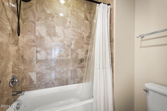 bathroom featuring shower / bath combination with curtain and toilet