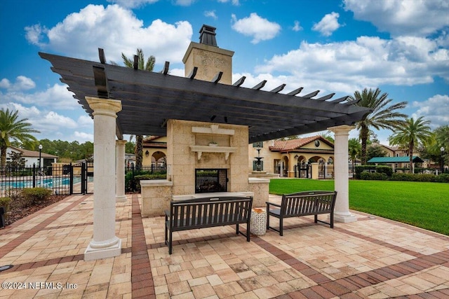 view of patio with a community pool, a pergola, and a tiled fireplace