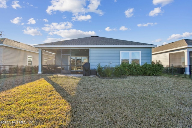 rear view of house with a sunroom and a lawn