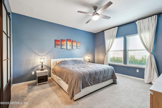 carpeted bedroom with ceiling fan and a textured ceiling