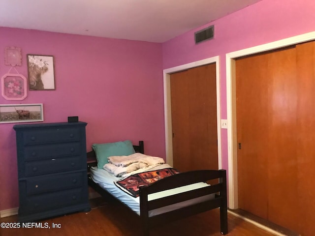 bedroom with dark wood-type flooring