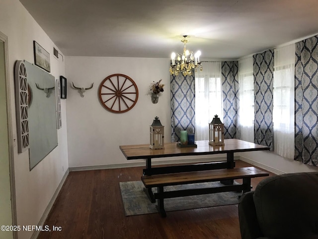 dining room with dark hardwood / wood-style floors and a notable chandelier