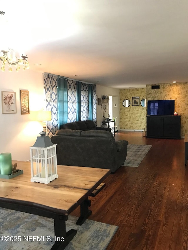 living room with wood-type flooring and an inviting chandelier