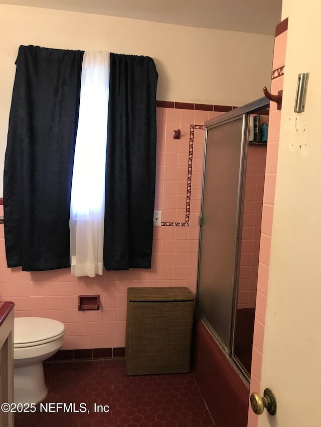 full bathroom with tile patterned flooring, plenty of natural light, toilet, and tile walls