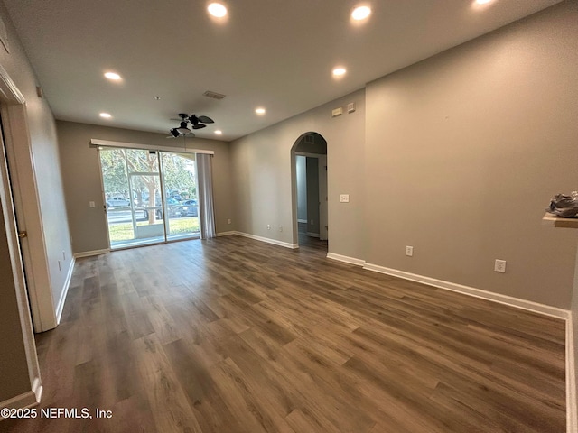 empty room with ceiling fan and dark wood-type flooring