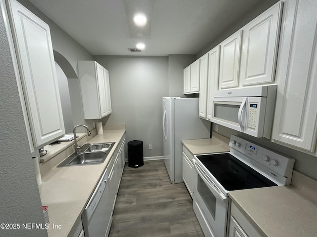 kitchen with white cabinetry, dark hardwood / wood-style flooring, white appliances, and sink