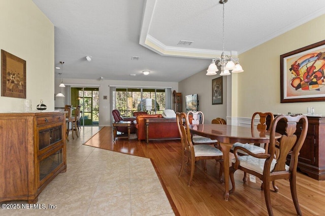 dining space with an inviting chandelier, crown molding, and light hardwood / wood-style floors