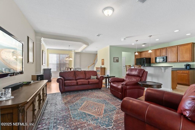 living room featuring an inviting chandelier and a textured ceiling