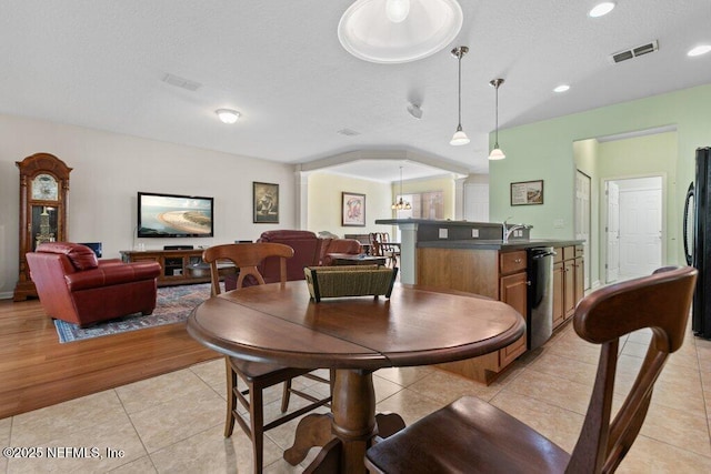 dining area featuring light tile patterned floors and a textured ceiling