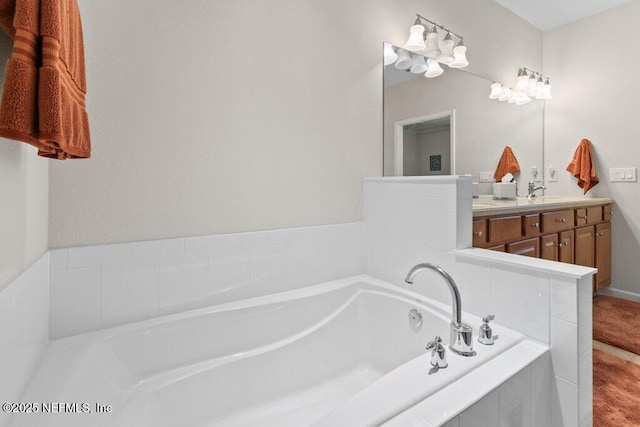 bathroom featuring a relaxing tiled tub and vanity