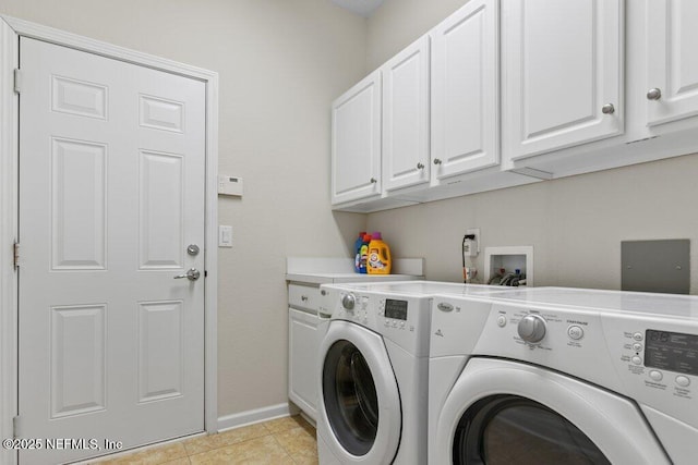 washroom featuring light tile patterned floors, cabinets, and washer and dryer