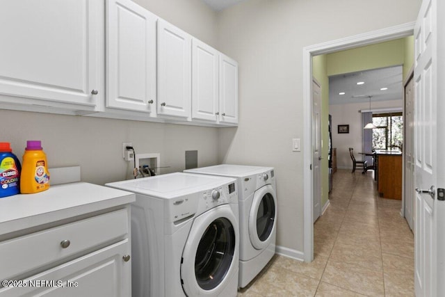 laundry room featuring light tile patterned flooring, independent washer and dryer, and cabinets