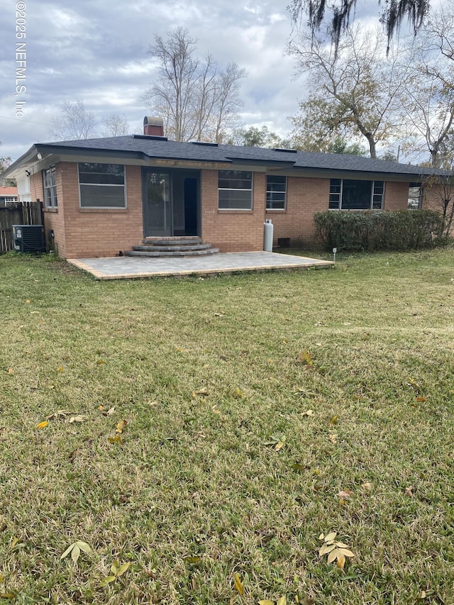 rear view of house with a lawn, central air condition unit, and a patio