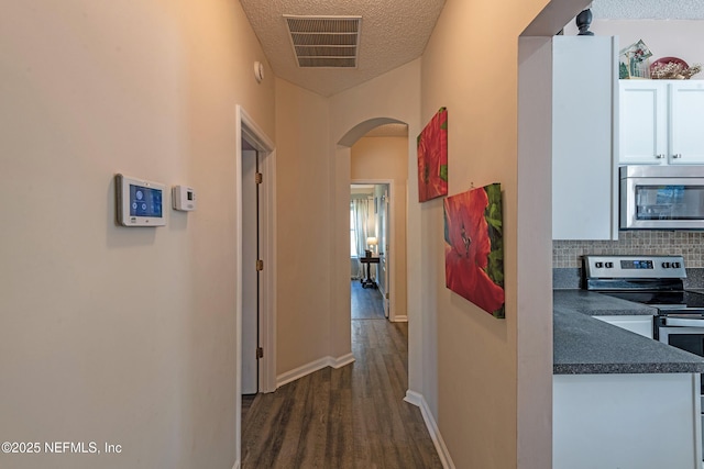 hallway featuring dark hardwood / wood-style flooring and a textured ceiling