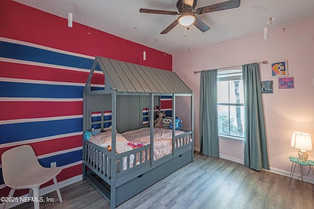 bedroom featuring wood-type flooring, a textured ceiling, and ceiling fan