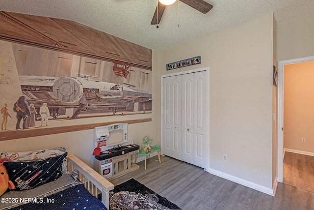 bedroom featuring a textured ceiling, a closet, ceiling fan, and dark wood-type flooring