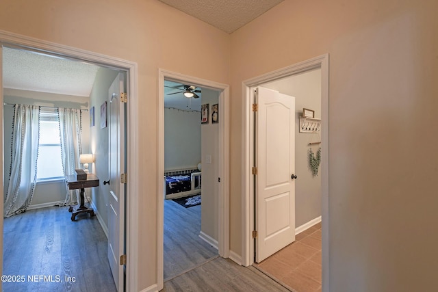 corridor featuring hardwood / wood-style flooring and a textured ceiling