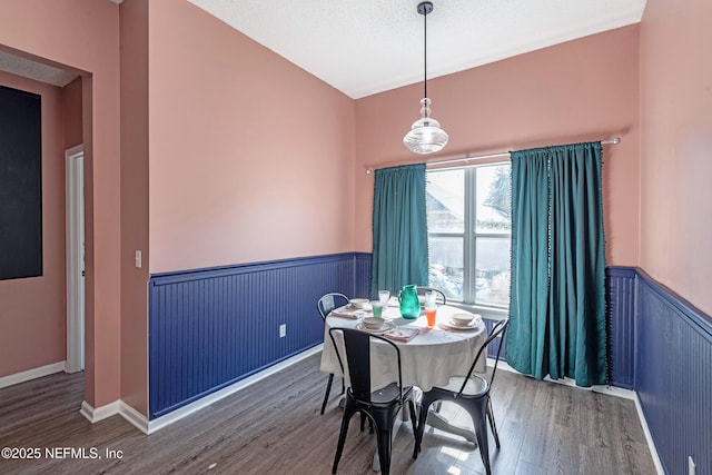 dining area with wood-type flooring and a textured ceiling