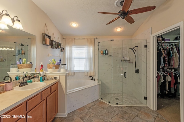 bathroom featuring vanity, a textured ceiling, separate shower and tub, ceiling fan, and lofted ceiling