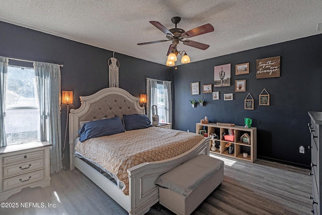 bedroom featuring multiple windows, a textured ceiling, and ceiling fan