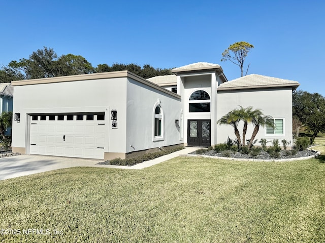 view of front of house with a front lawn, a garage, and french doors