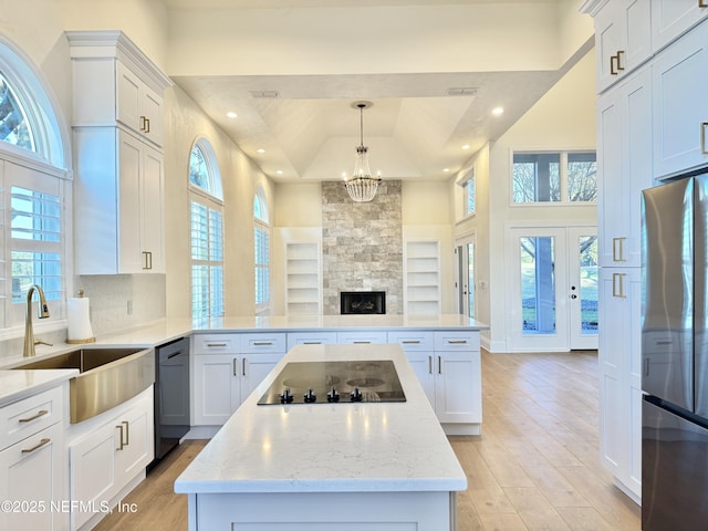 kitchen with sink, black appliances, and white cabinets