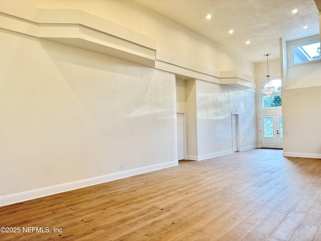 spare room with hardwood / wood-style flooring and a towering ceiling