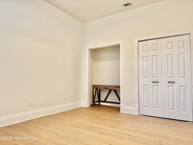 unfurnished bedroom featuring a closet and light wood-type flooring