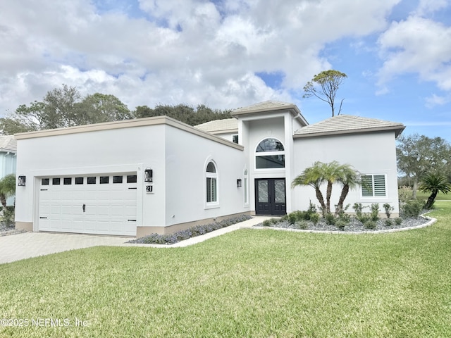 view of front of home with french doors, a garage, and a front lawn