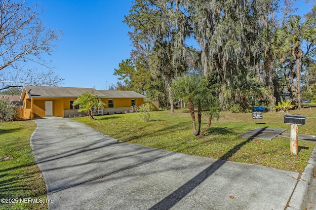 view of front of property featuring an attached carport, driveway, stucco siding, and a front lawn