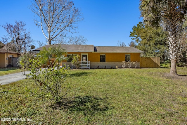 ranch-style house featuring fence, a front lawn, and stucco siding