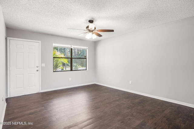 empty room with ceiling fan, baseboards, a textured ceiling, and dark wood-type flooring