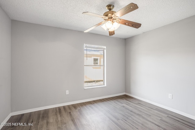 empty room featuring baseboards, a ceiling fan, light wood finished floors, and a textured ceiling