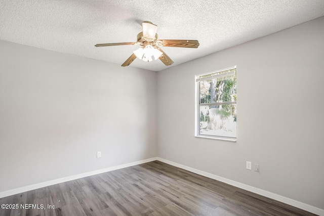 spare room with baseboards, a ceiling fan, wood finished floors, and a textured ceiling