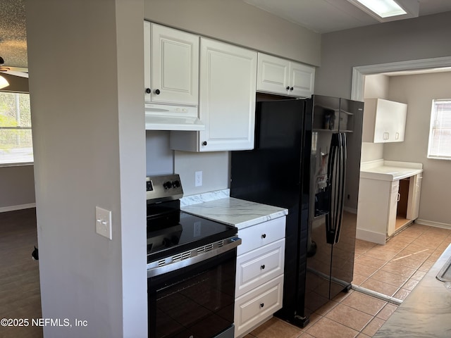 kitchen featuring light countertops, stainless steel range with electric stovetop, white cabinets, and under cabinet range hood