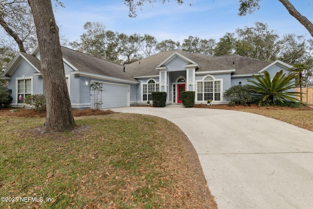 ranch-style home featuring a garage and a front lawn