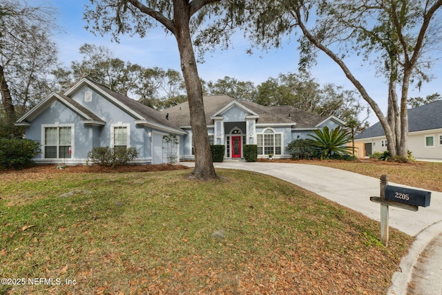 single story home with a garage and a front lawn