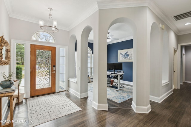 foyer entrance featuring dark wood-type flooring, ceiling fan with notable chandelier, and ornamental molding