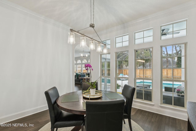 dining area with crown molding, dark wood-type flooring, and a chandelier