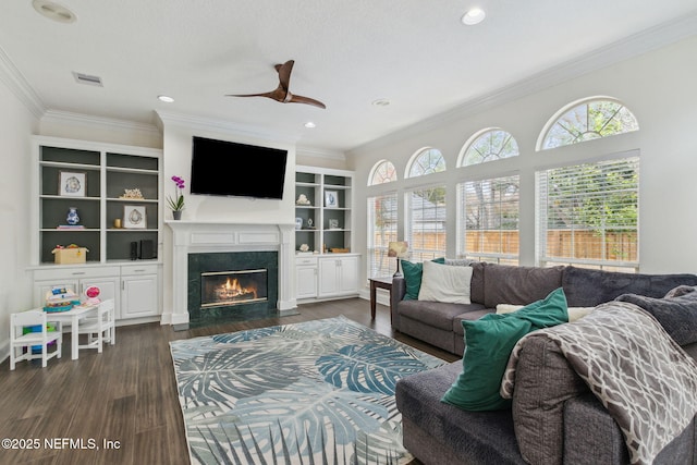 living room with a high end fireplace, dark hardwood / wood-style floors, plenty of natural light, and ceiling fan