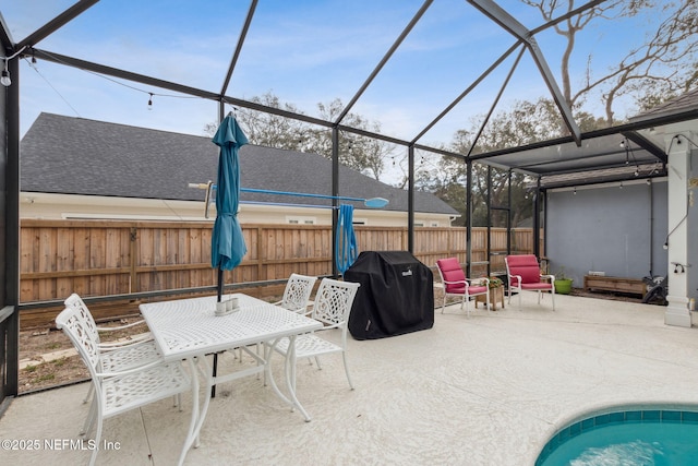 view of patio featuring glass enclosure and a grill