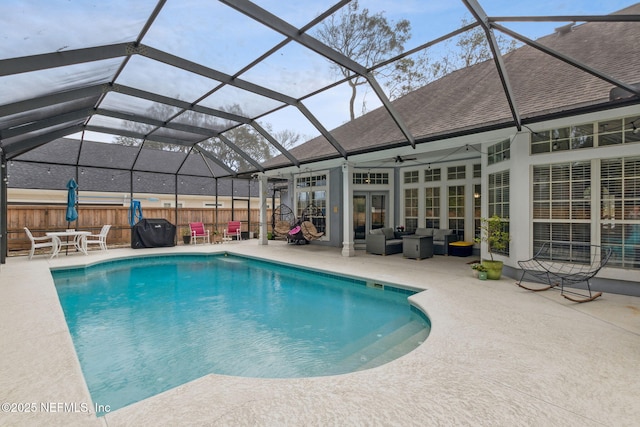 view of swimming pool with french doors, outdoor lounge area, ceiling fan, glass enclosure, and a patio