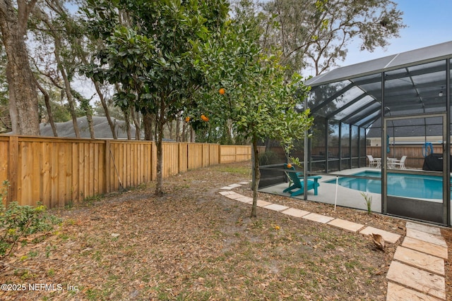 view of yard with a fenced in pool and glass enclosure