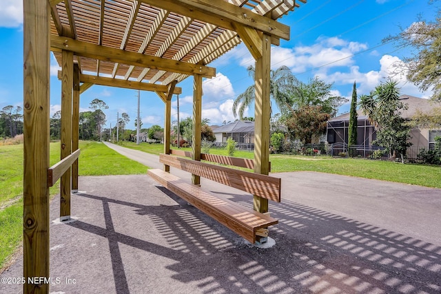 view of community featuring a pergola, a patio, and a lawn