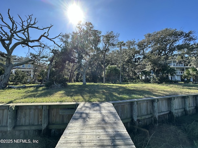 view of dock featuring a lawn