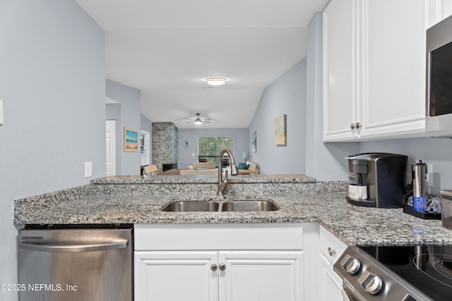 kitchen with stainless steel appliances, ceiling fan, sink, white cabinetry, and lofted ceiling