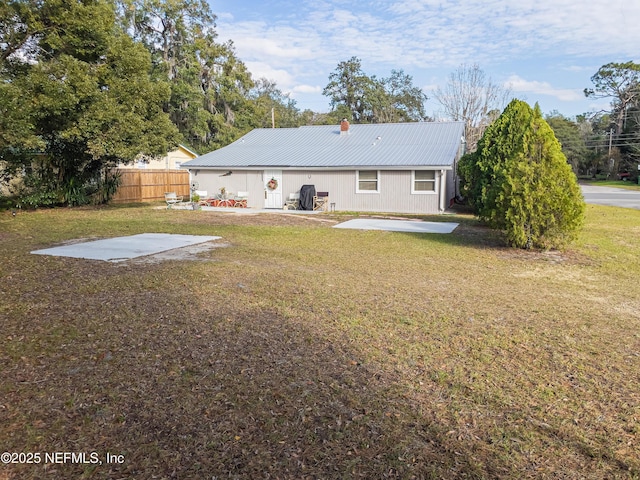 rear view of property featuring a patio area and a yard