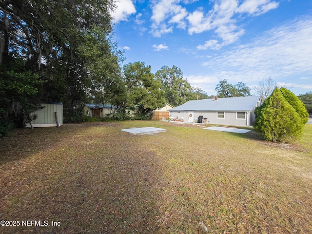 view of yard with a shed and a patio area