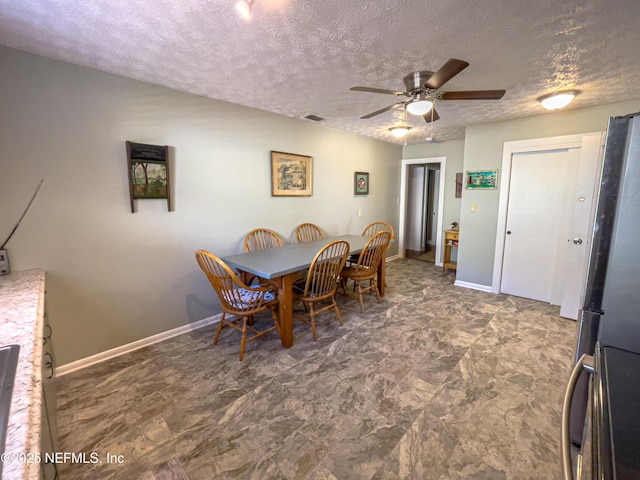 dining room featuring ceiling fan and a textured ceiling